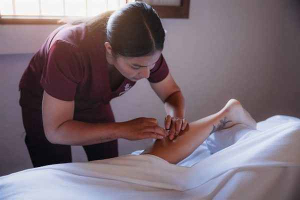 Physiotherapist applying dry needling to shoulder muscle at Healing Hands, Antigua Guatemala